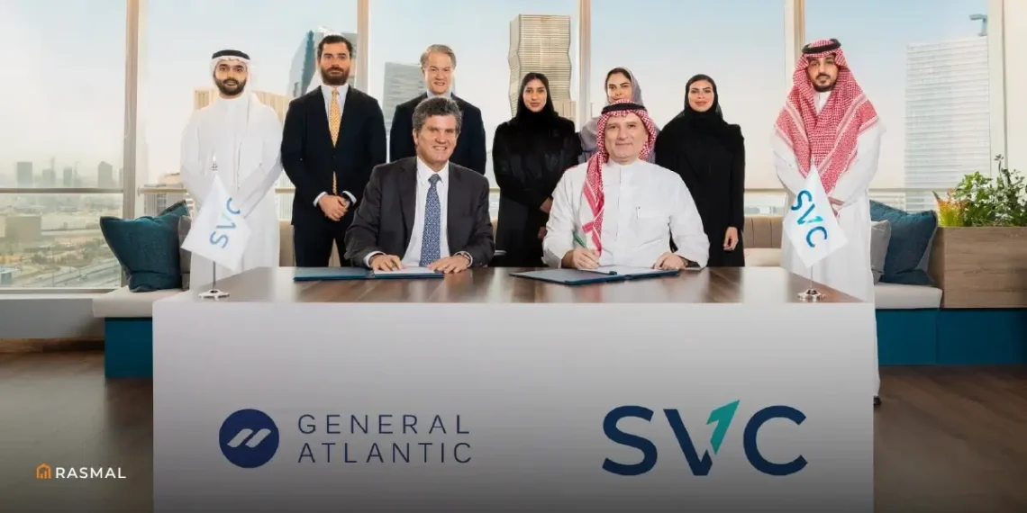 A group photo showing the team from SVC and General Atlantic after signing an investment agreement, with men in traditional Saudi and Emirati attire and women in modest clothing, seated at a long table with the SVC and General Atlantic logos displayed.