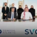 A group photo showing the team from SVC and General Atlantic after signing an investment agreement, with men in traditional Saudi and Emirati attire and women in modest clothing, seated at a long table with the SVC and General Atlantic logos displayed.
