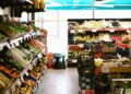A variety of fresh fruits, vegetables, and groceries neatly displayed in a UAE grocery store.